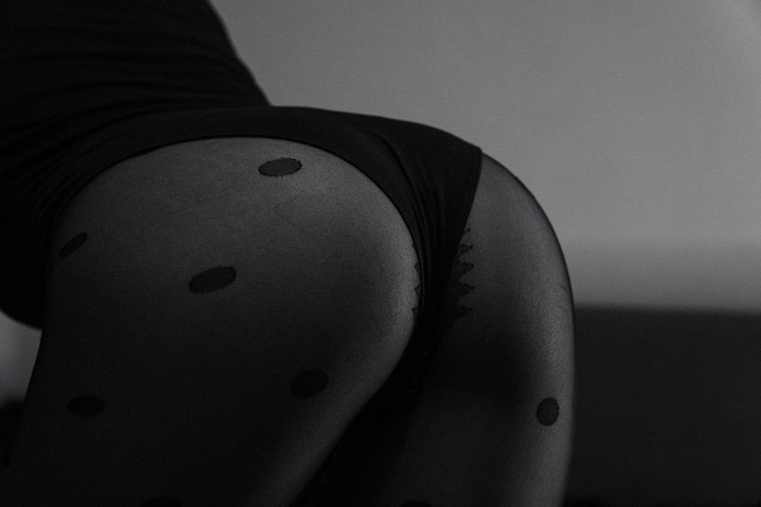 Sinnliche Schwarz-Weiß-Fotografie: Frau in schwarzem Body und Tupfenstrumpfhose – Titelbild für den fishbelly Guide zu extra heißer Lingerie.