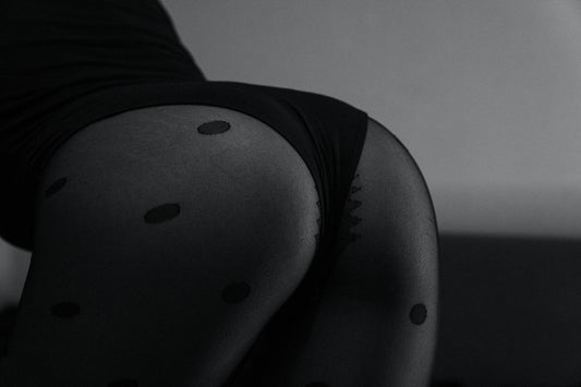 Sinnliche Schwarz-Weiß-Fotografie: Frau in schwarzem Body und Tupfenstrumpfhose – Titelbild für den fishbelly Guide zu extra heißer Lingerie.
