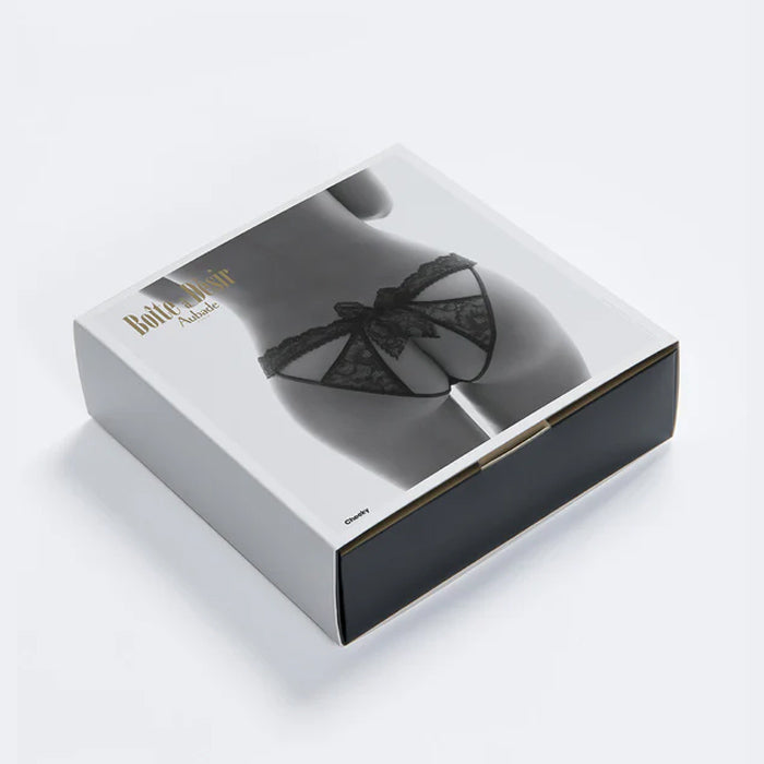 Schwarzer pofreier Spitzenslip von Aubade Paris aus der Dessous-Serie BOÎTE À DÉSIR mit raffinierten Ausschnitten am Rückenteil - Geschenkbox