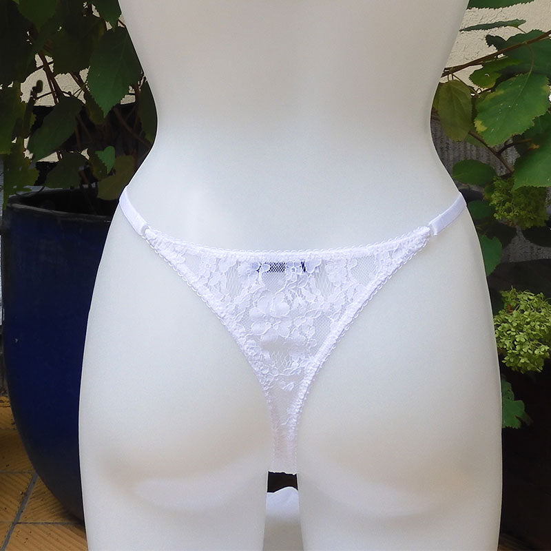 Weißer Tanga-String aus zarter, durchbrochener Spitze mit einem braun-weißen Rüschendetails verziert von fishbelly Lingerie - handmade in Berlin - Rückansicht